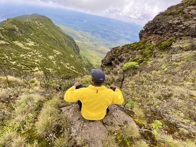 Hiker sitting on a cliff near Elephant Hill summit - Elephant hill hike